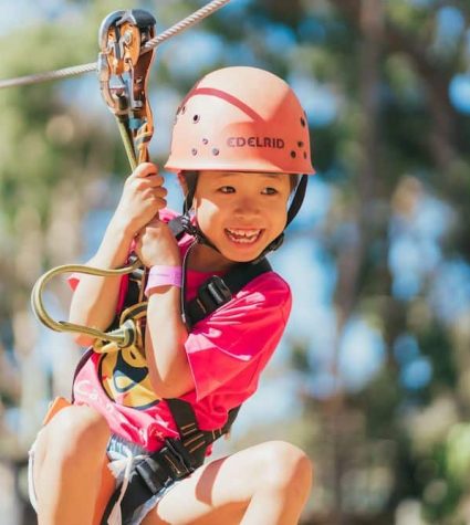 child on a zipline at a camp for cancer patients and families